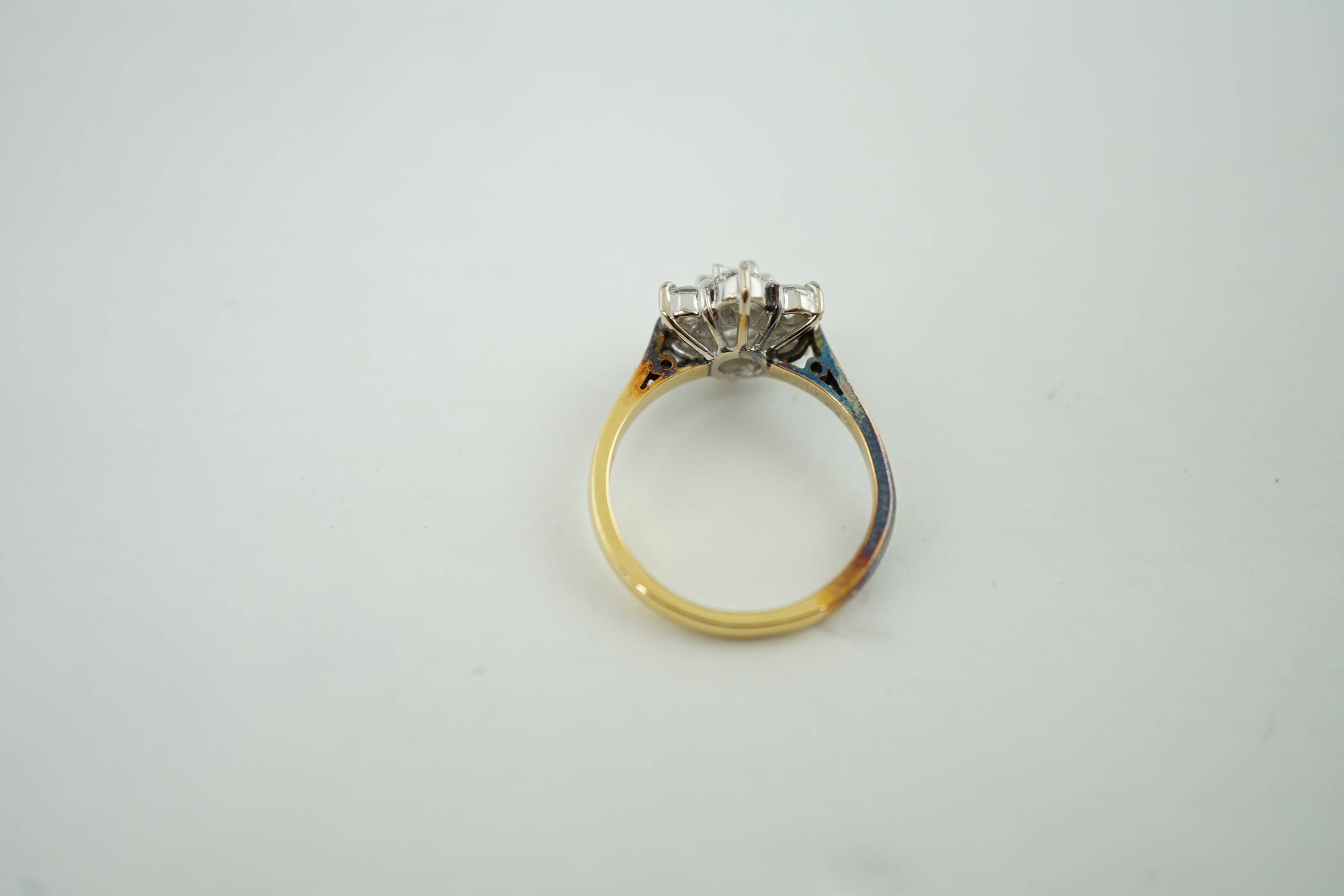 A modern 18ct gold and seven stone diamond set flower head cluster ring